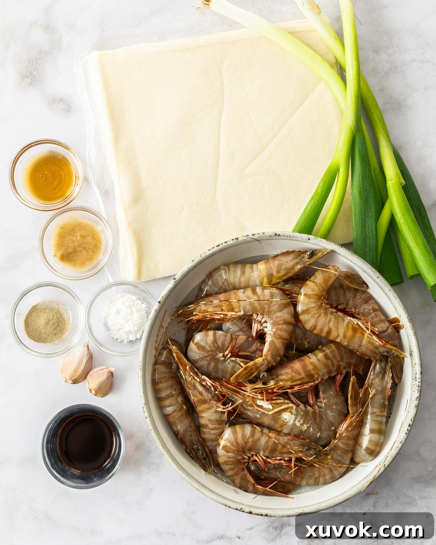 Ingredients for prawn spring rolls on a marble surface, neatly arranged.