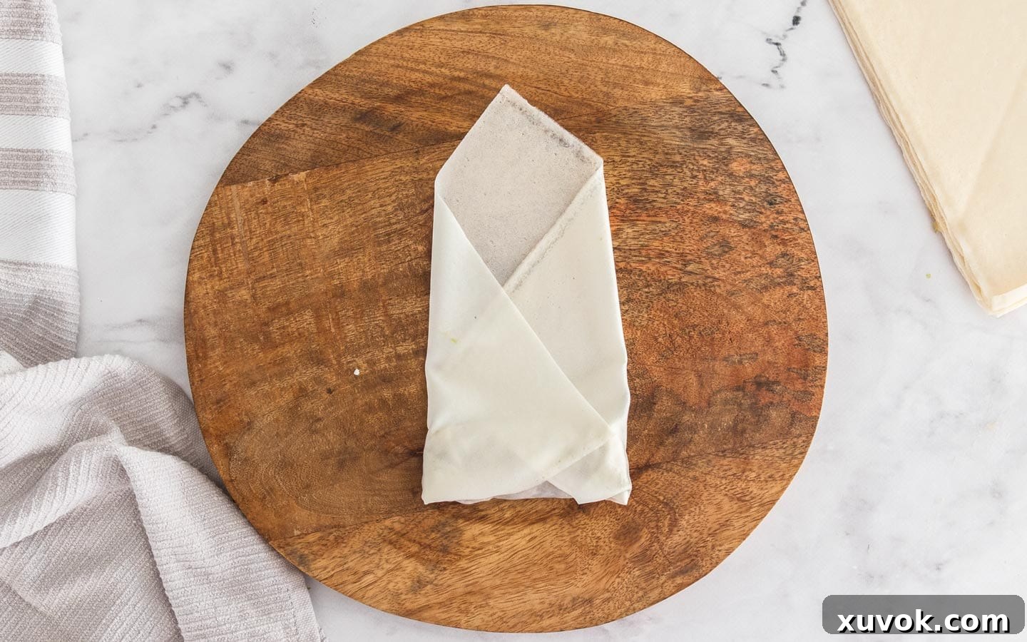 The sides of the spring roll wrapper folded into the middle, forming an envelope.