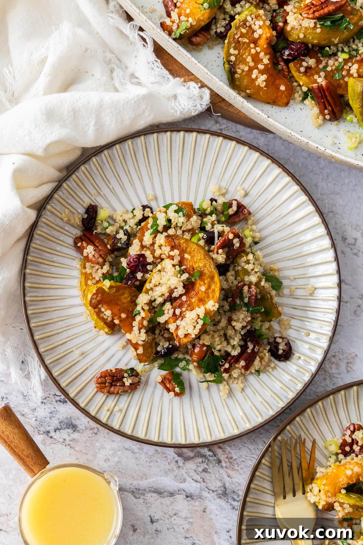 A close-up, top-down view of a single serving of pumpkin quinoa salad on a white plate, showcasing the diverse ingredients.