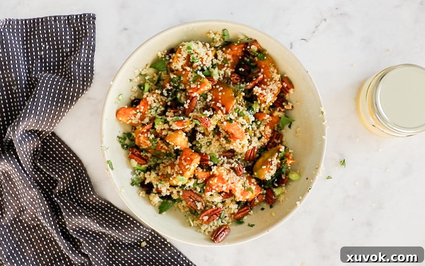 The pumpkin quinoa salad mixed together in a large bowl, showcasing the colorful ingredients and textures, ready for serving.