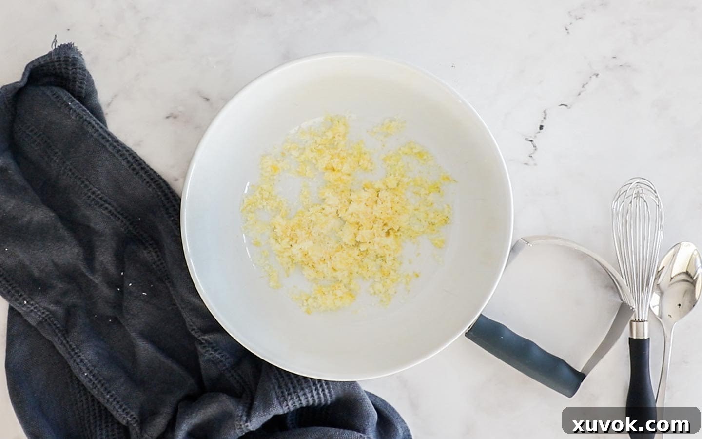 Lemon and sugar blended together in a mixing bowl for scone dough.