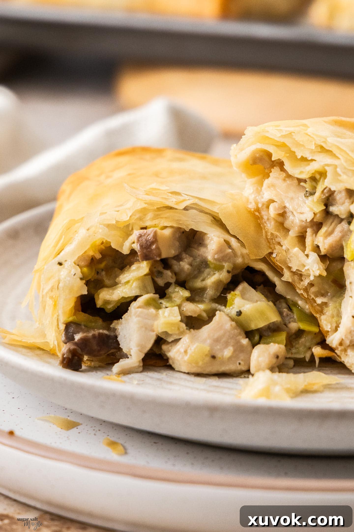 A close-up view of the rich, creamy chicken, leek, and mushroom filling inside a filo parcel, showcasing its inviting texture and appetizing appeal.
