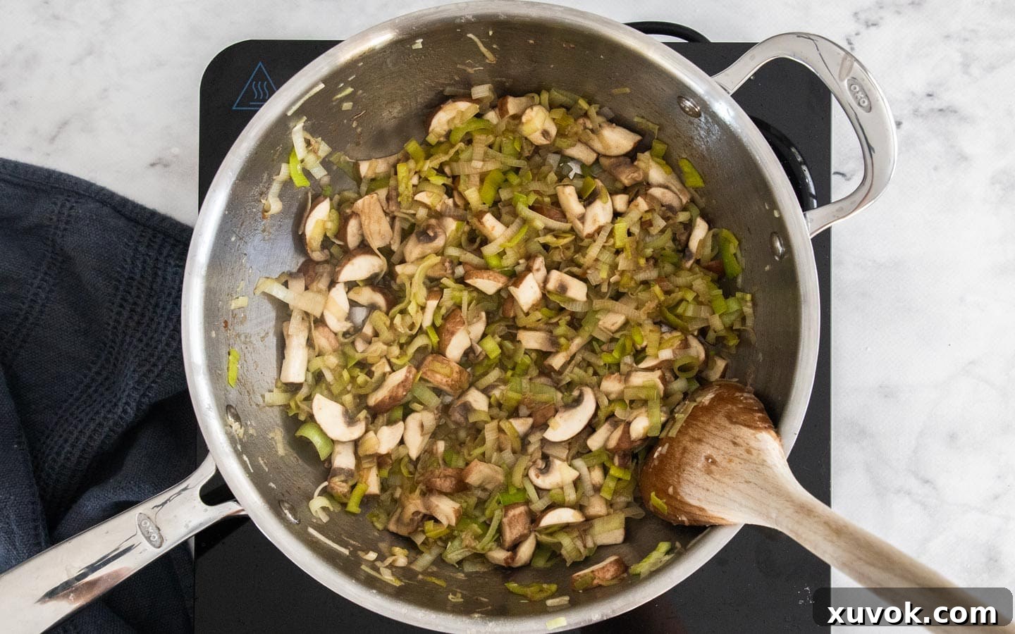 Chopped mushrooms and sliced leeks gently sautéing in a pan with garlic, softening and releasing their aromatic juices.