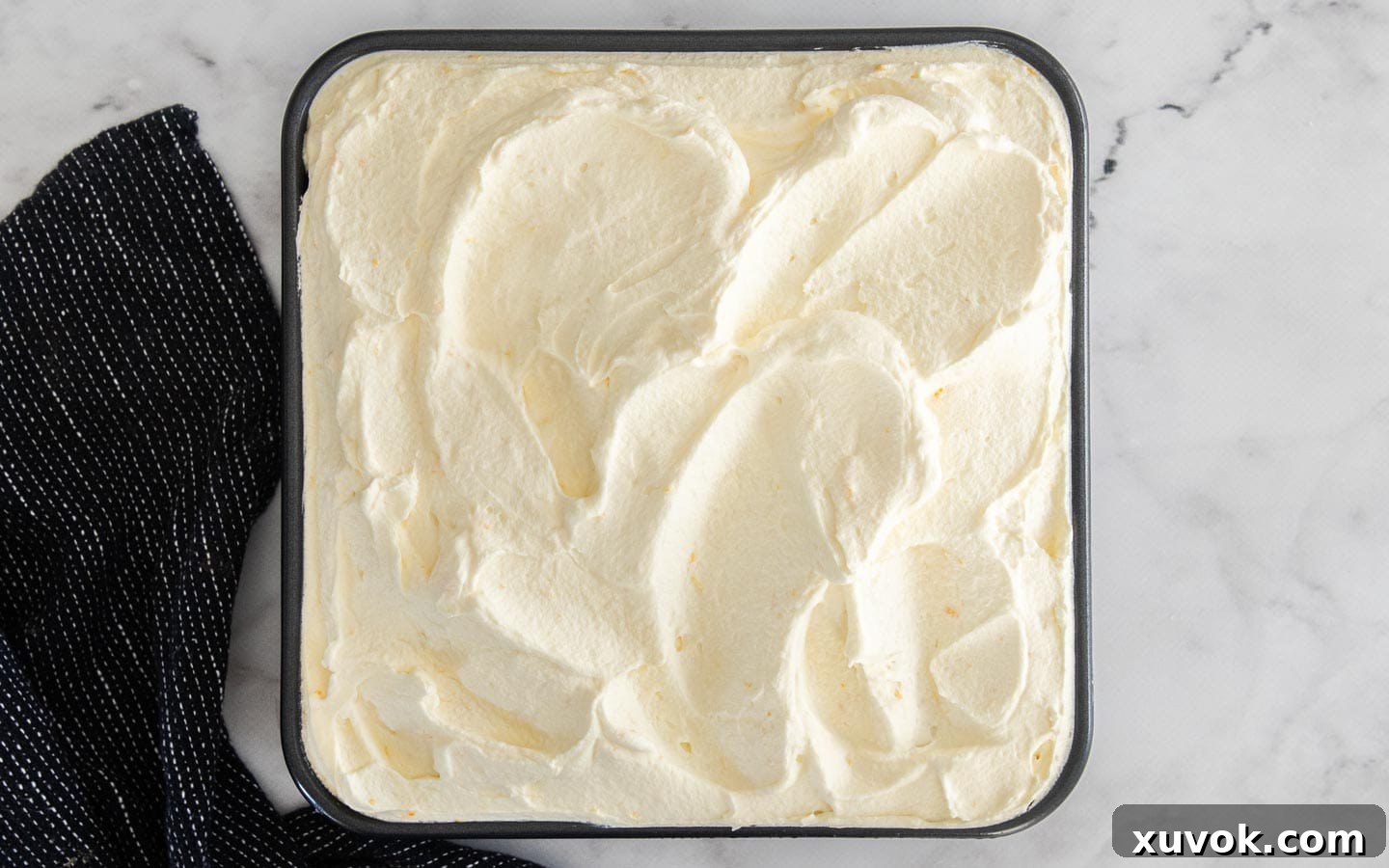 The final layer of smooth, piped mascarpone cream on top of the orange tiramisu, ready for chilling.