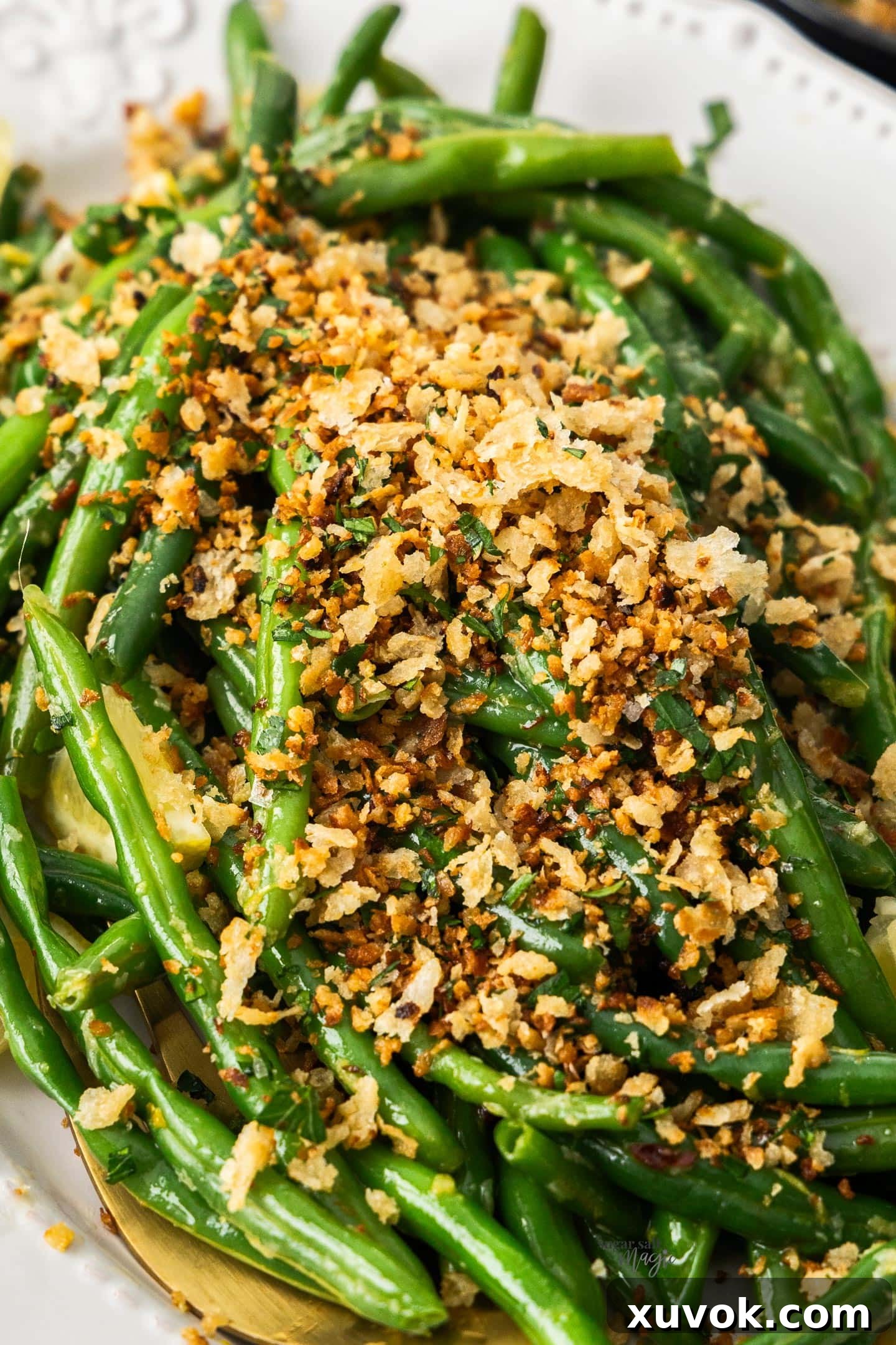 Freshly prepared pangrattato generously sprinkled over a vibrant serving of cooked green beans, showcasing its perfect application as a versatile, flavorful topping.