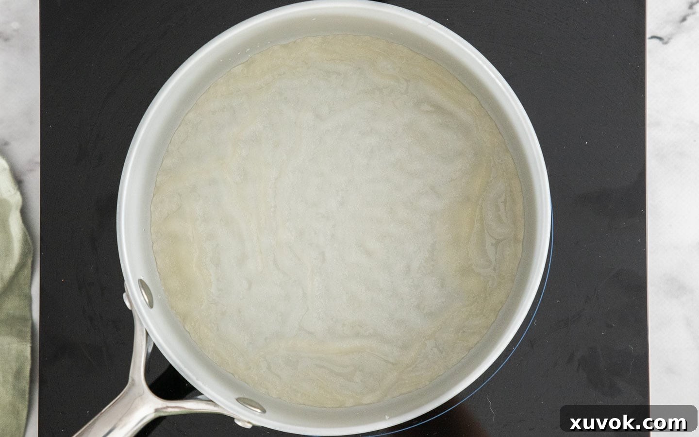 Gelatine softened on top of water in a saucepan, showing the blooming process.
