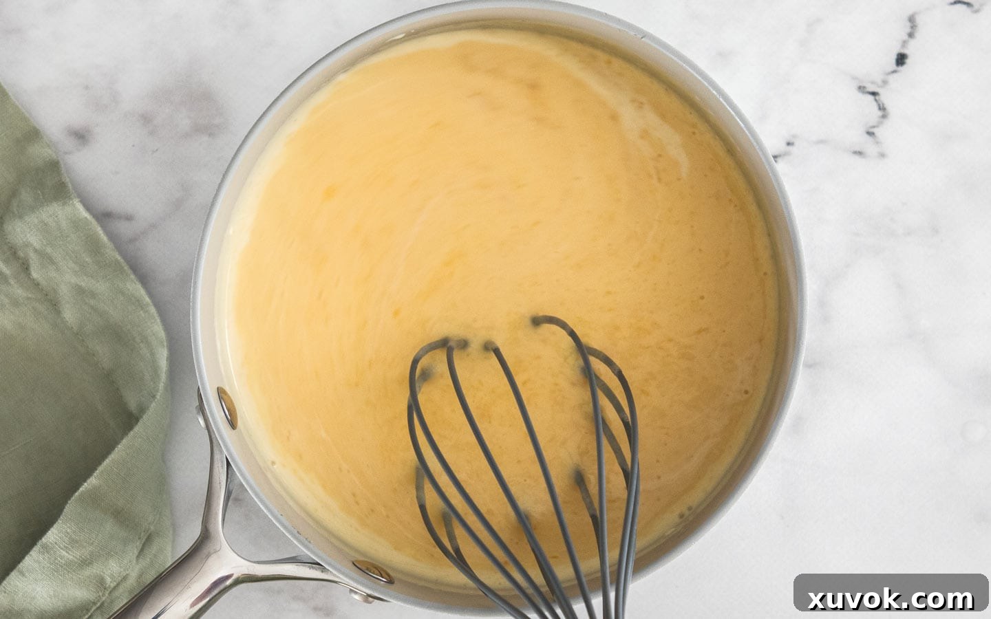 Whisking mango puree and cream into the warm gelatin mixture until smooth.