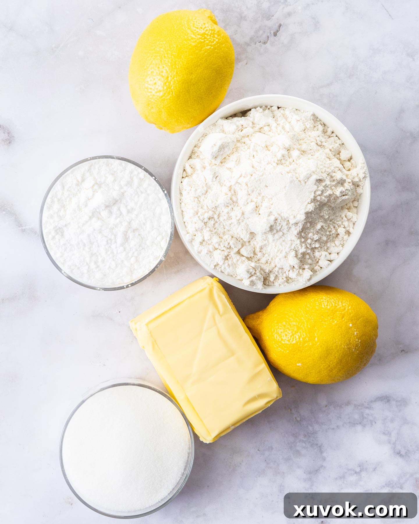 Ingredients for lemon shortbread on a marble surface.