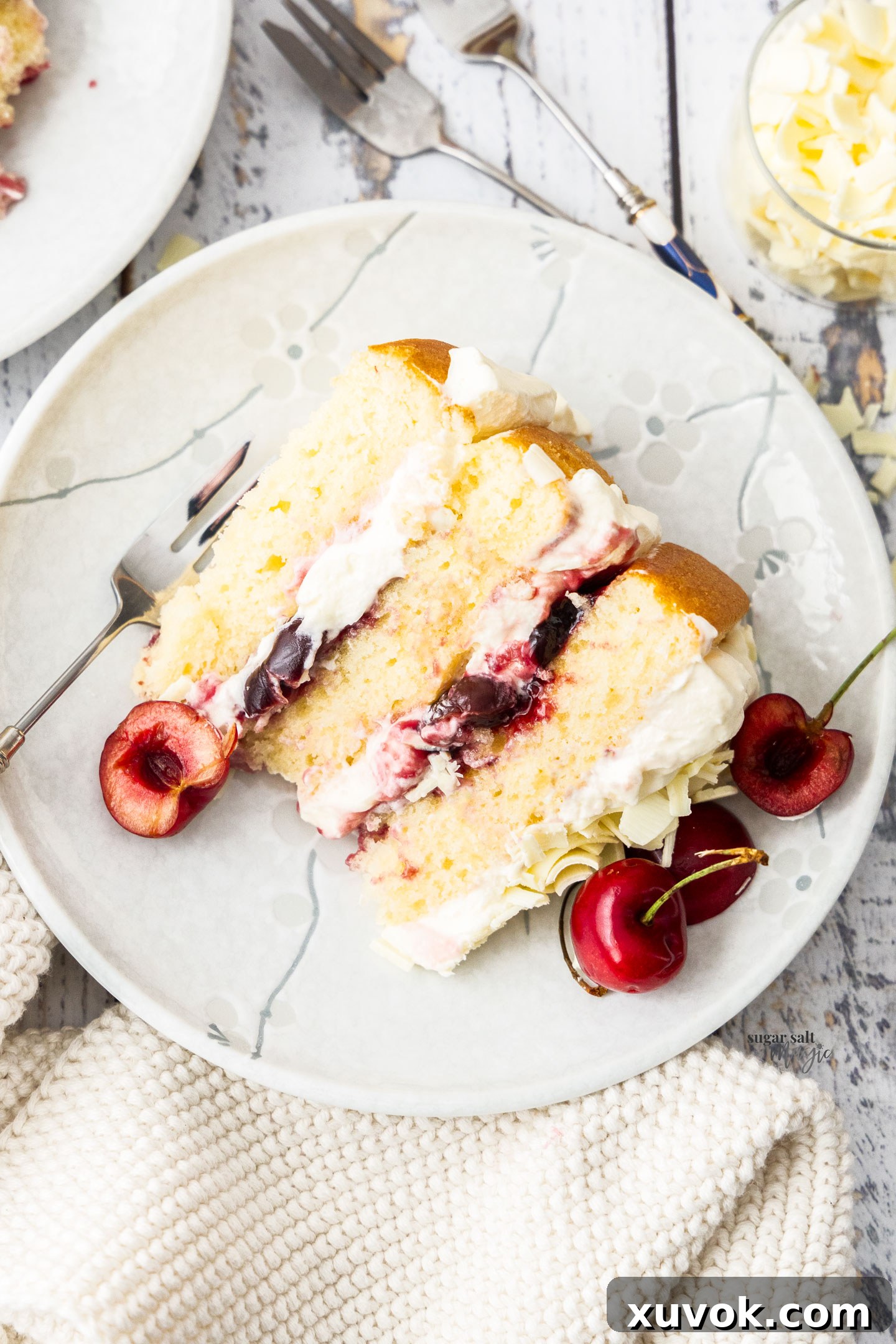 Top-down view of a single slice of white forest cake on a dessert plate, showcasing its layers.