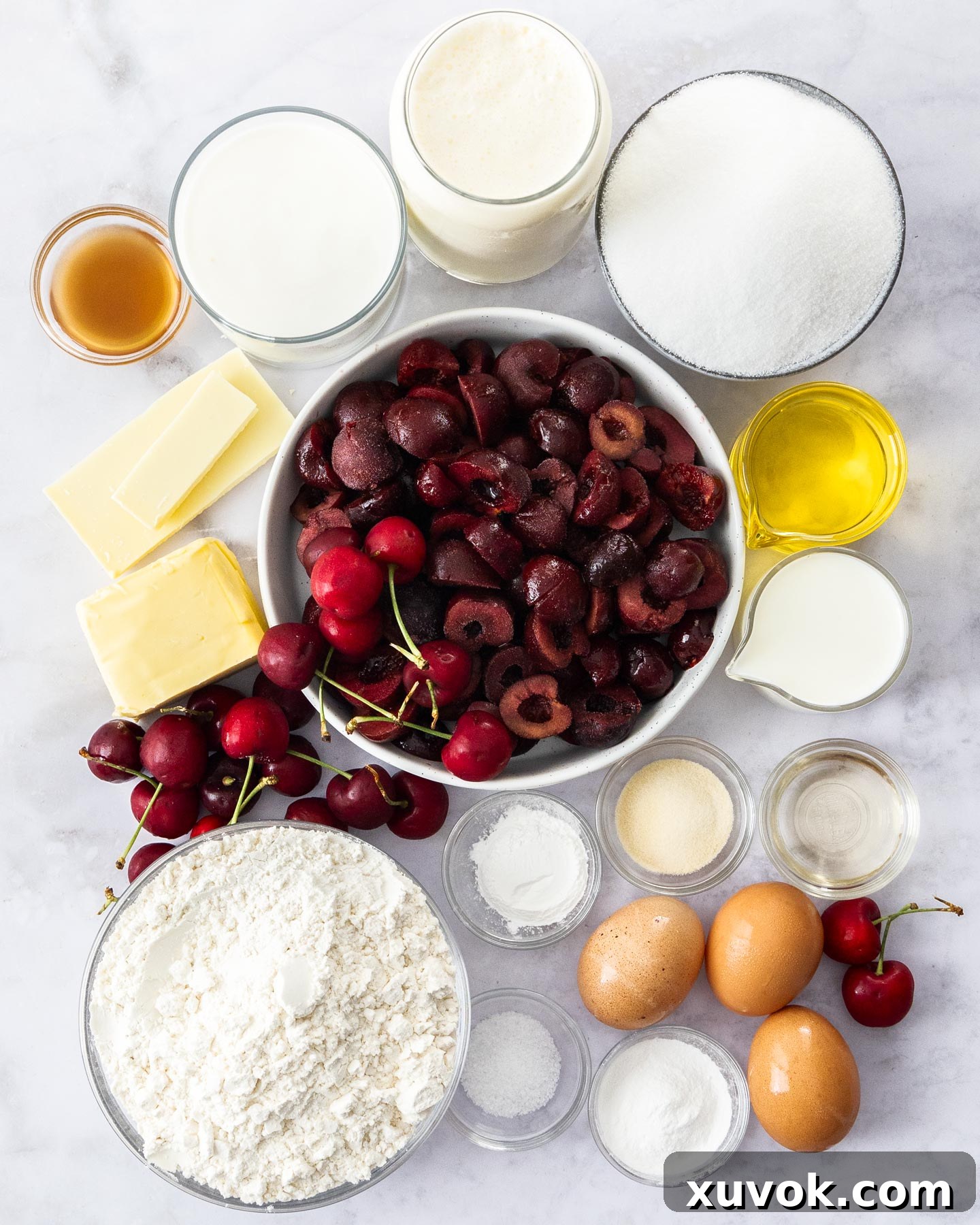 Assortment of fresh ingredients for making white forest cake, including eggs, butter, flour, and cherries.