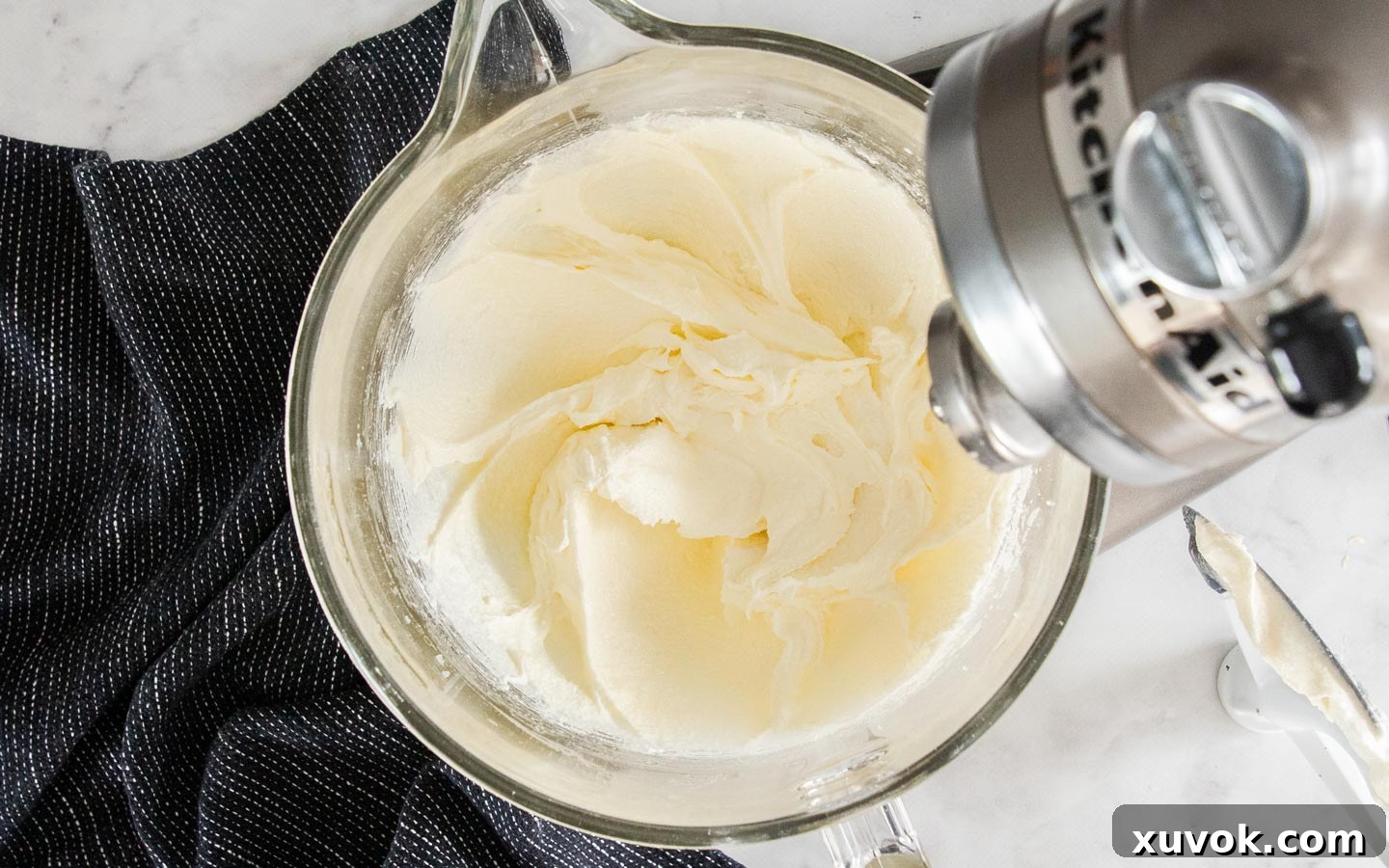 Creamed butter, oil, and sugar in a mixing bowl, showing a pale and fluffy texture.