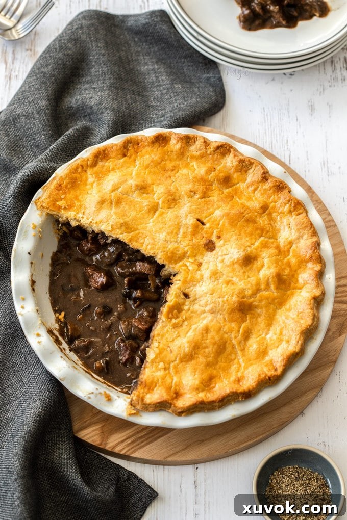 Birdseye view of a steak pie with part of the top cut out, showcasing the rich filling.