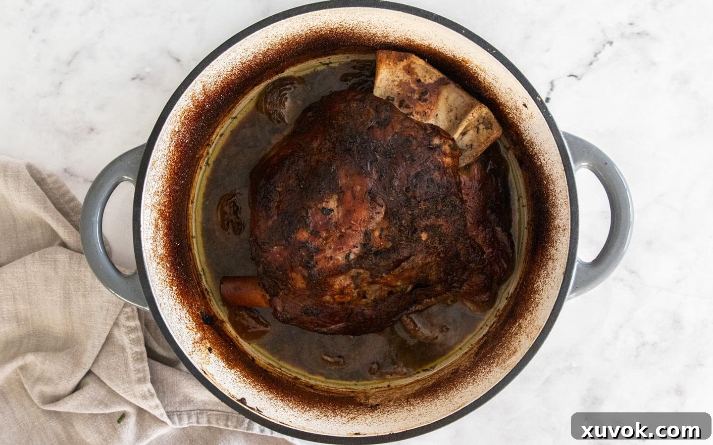 Perfectly roasted slow cooked pulled lamb shoulder in a Dutch oven after full cooking time, ready to be shredded.