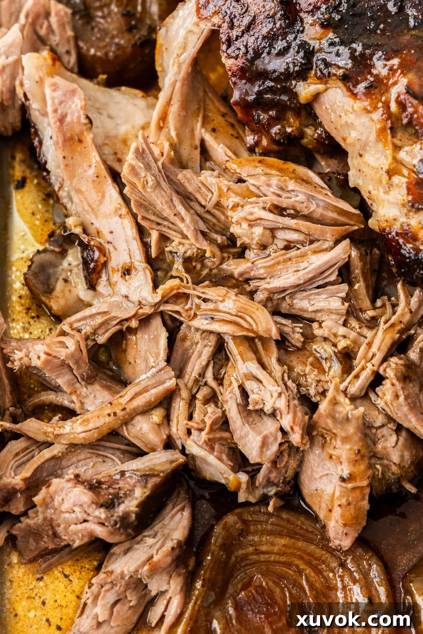 Close up shot of perfectly shredded slow cooked pulled lamb, showcasing its tender, juicy texture.