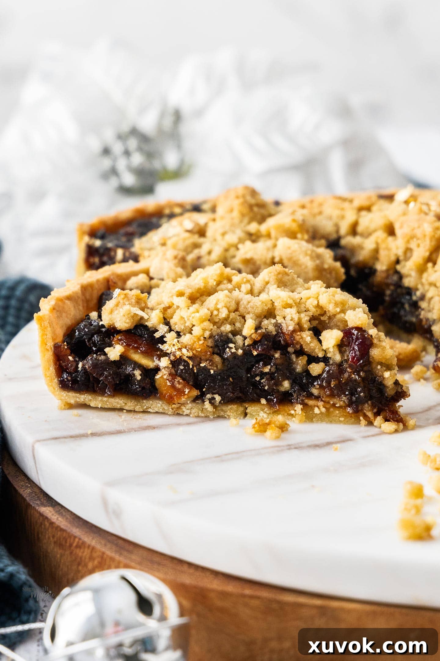 A slice of fruit mince tart on a marble platter.
