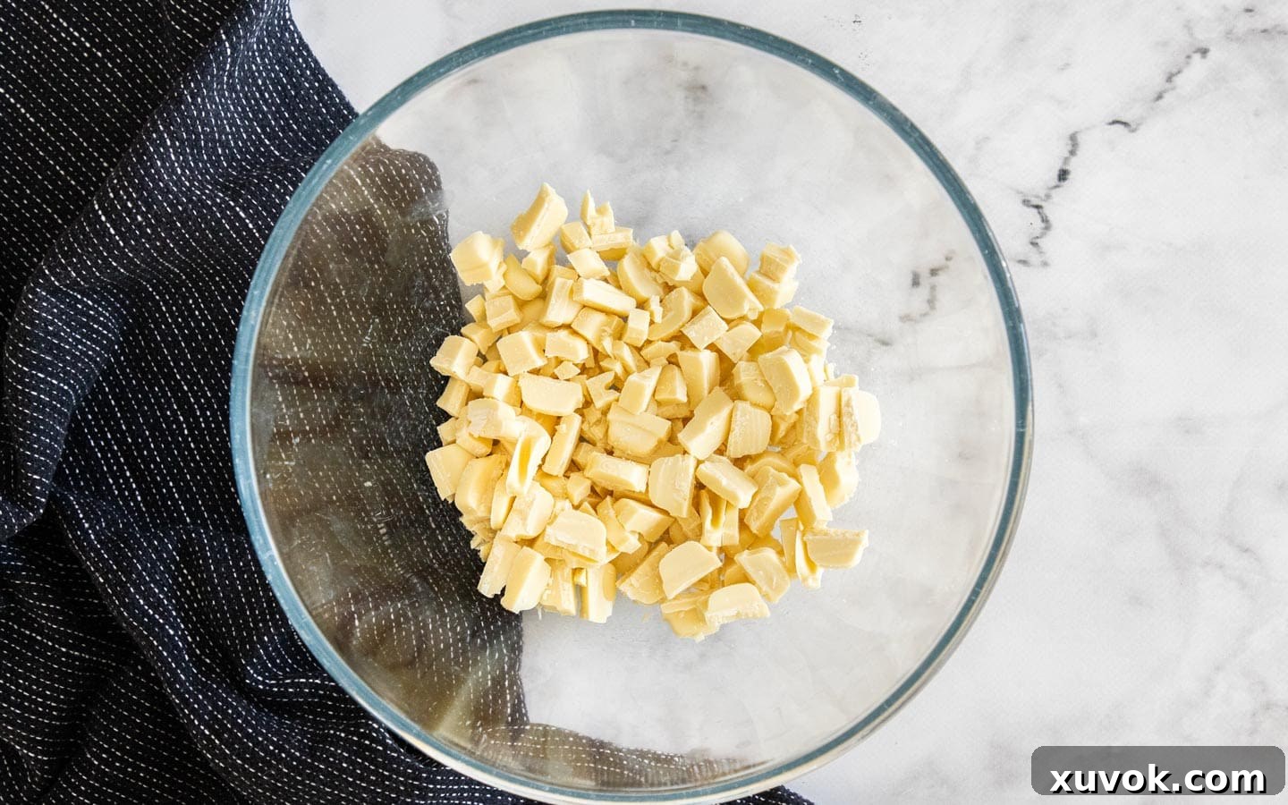Chunks of white chocolate in a mixing bowl, ready to be melted.