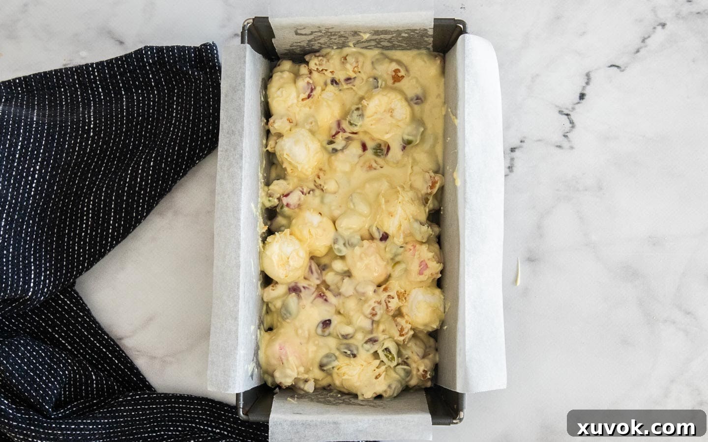The white chocolate rocky road mixture pressed into a loaf pan, ready for chilling.