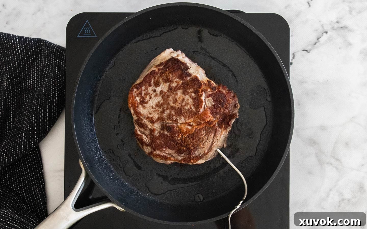 Steak cooking in a pan.