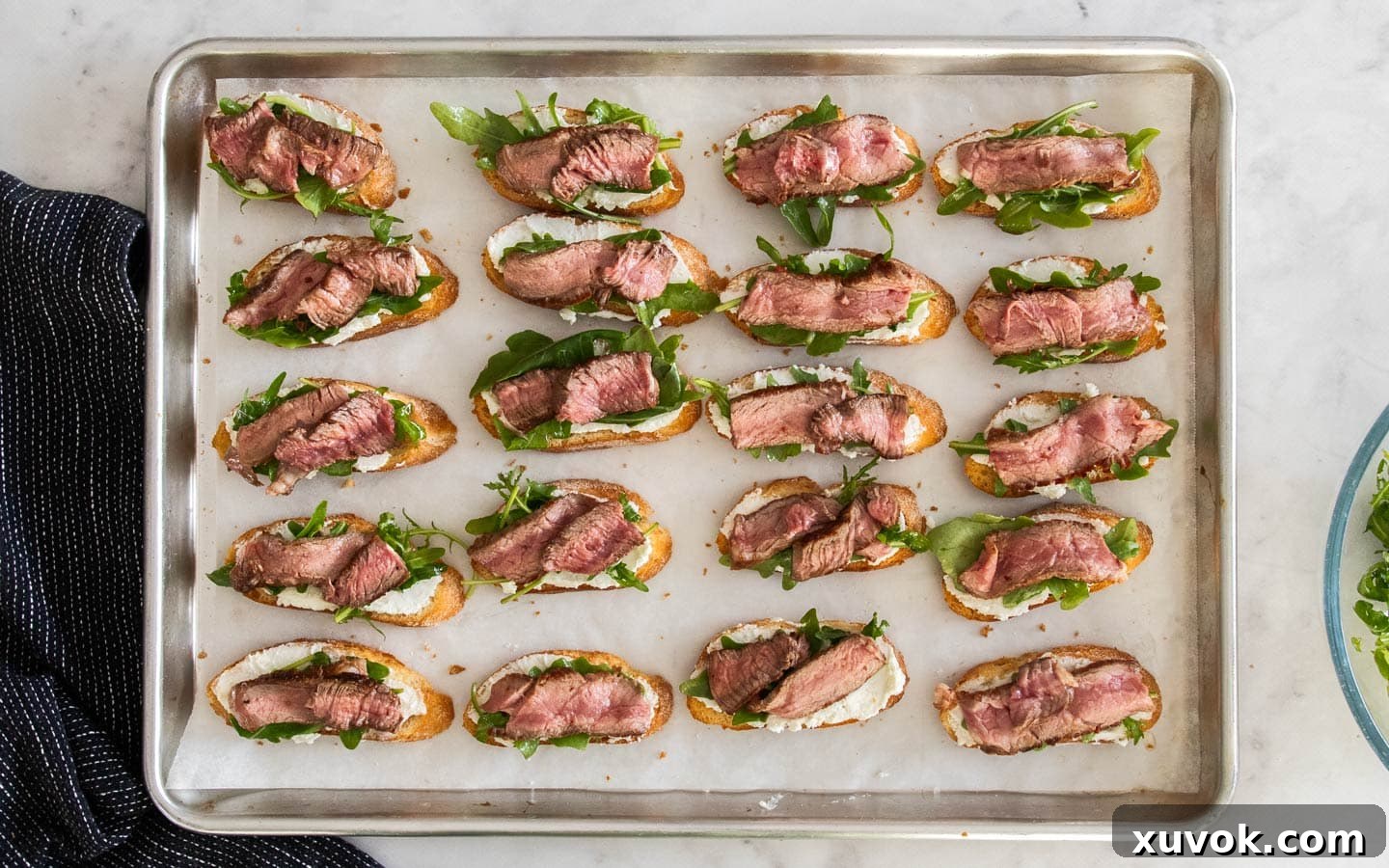 The crostini topped with goats cheese, rocket and slices of steak.