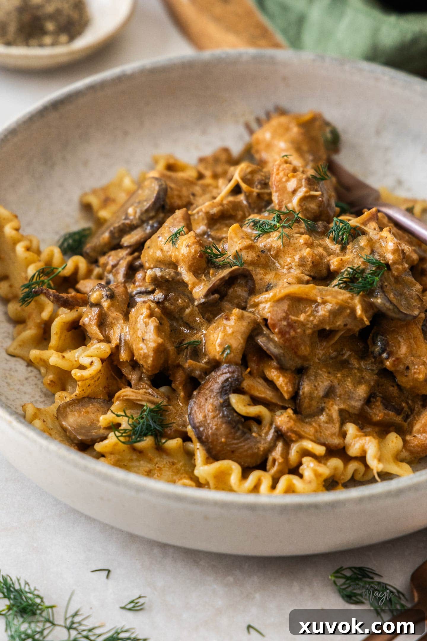 Slow cooker chicken stroganoff served with pasta in a bowl, ready to eat.