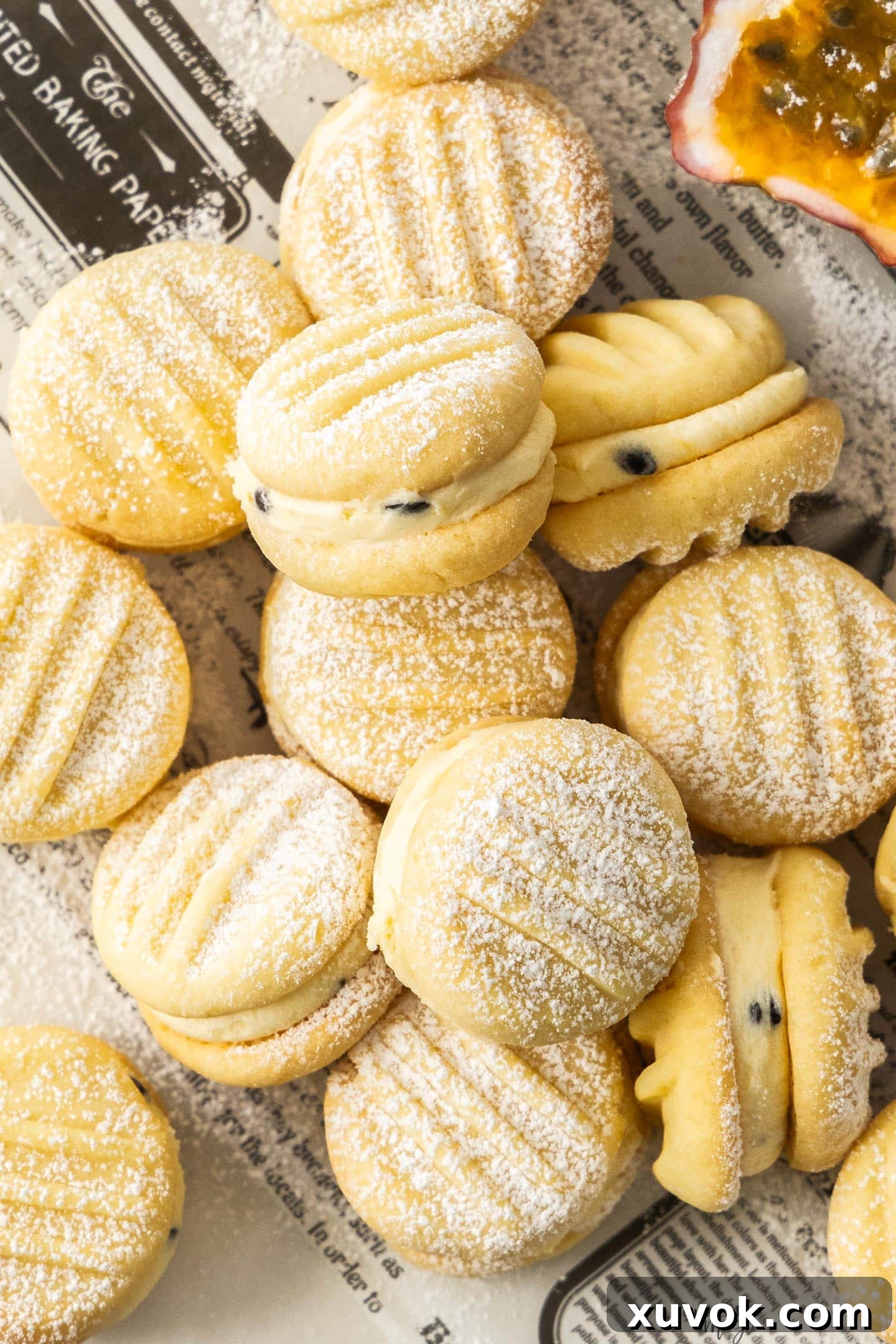 A batch of passionfruit melting moments, dusted with icing sugar. Close-up view highlighting the delicate texture and tropical filling.