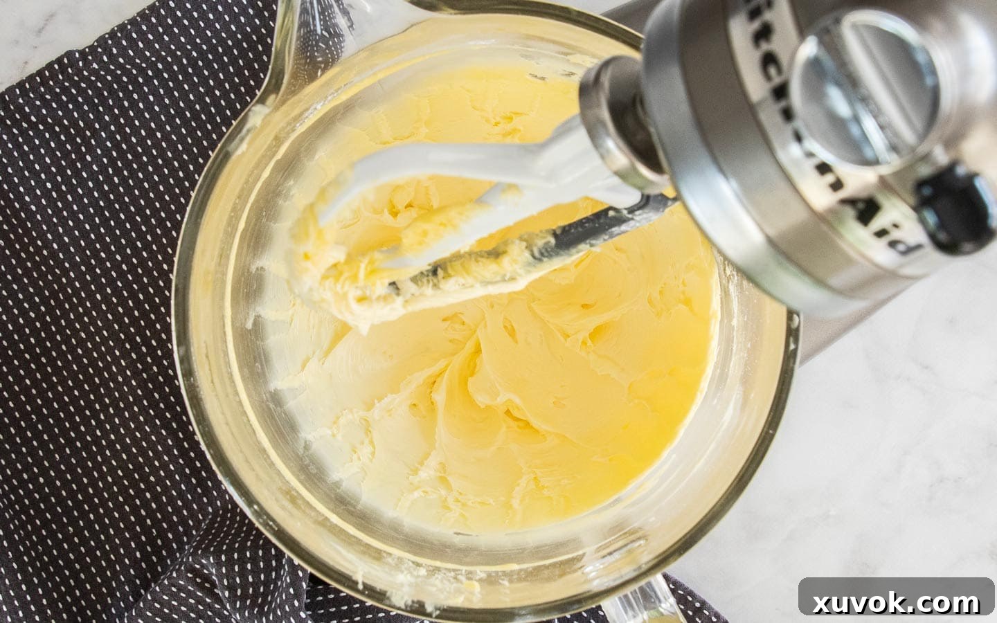 The butter and sugar creamed together in a stand mixer bowl, showing a pale, fluffy consistency.