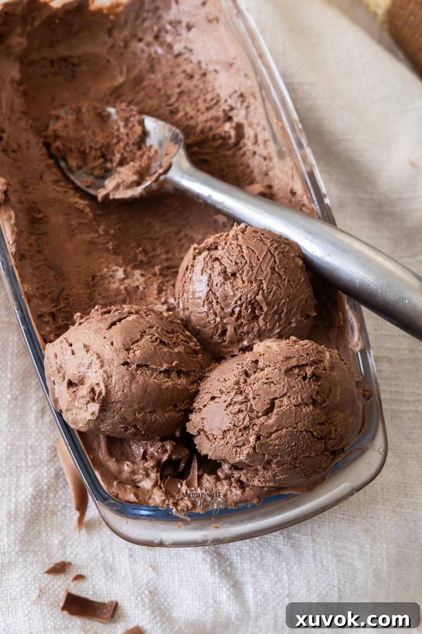 Top down view of scoops of chocolate ice cream in a glass loaf pan.