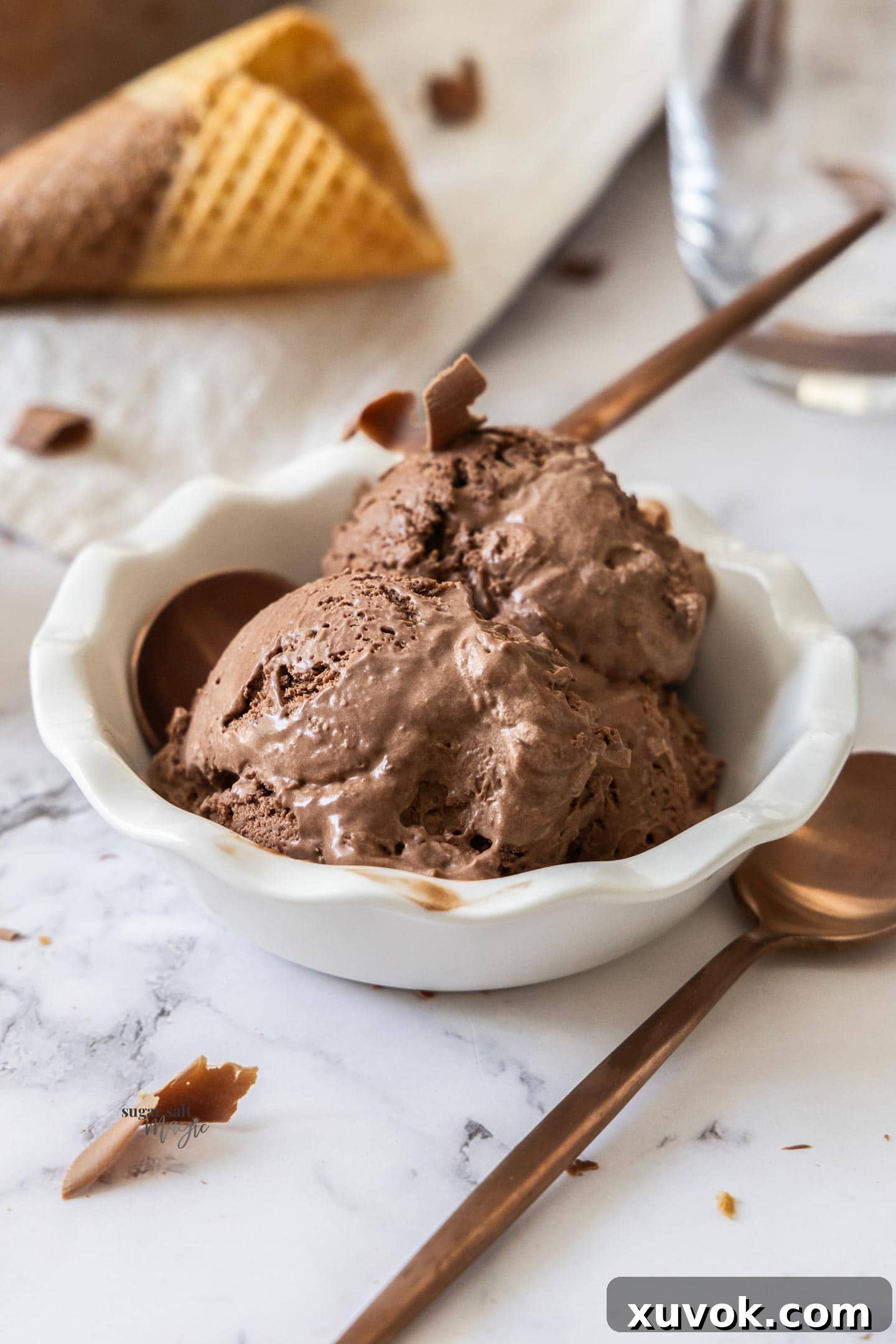 A bowl filled with scoops of chocolate chocolate chip ice cream.