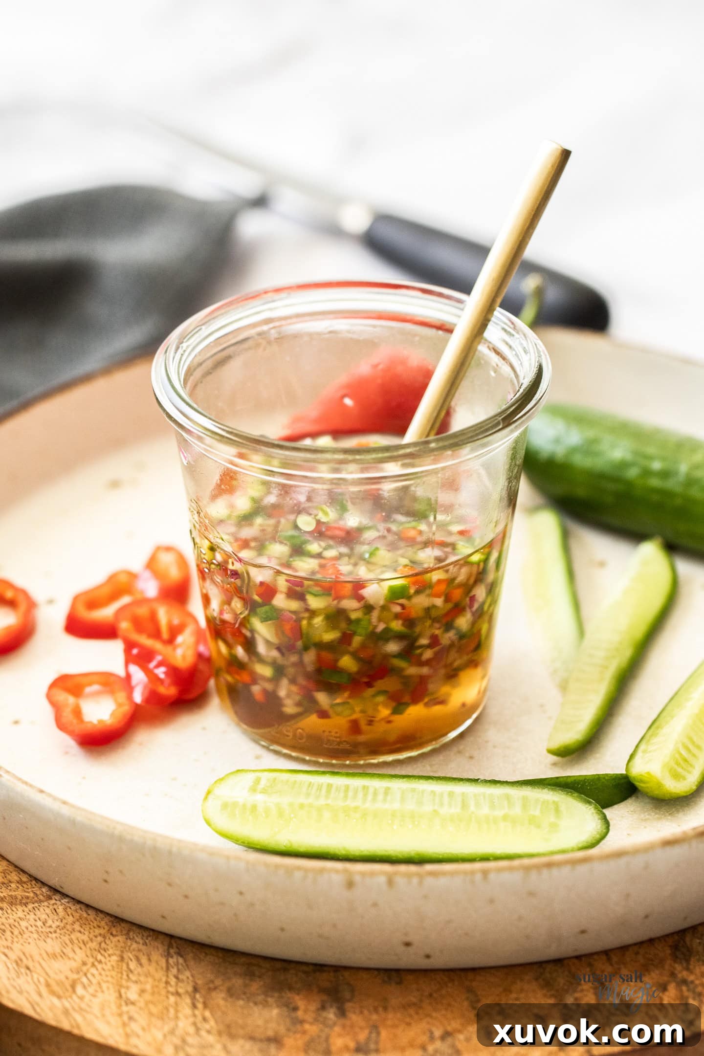 A glass jar with ajaad sauce, showcasing its vibrant color and fresh ingredients.