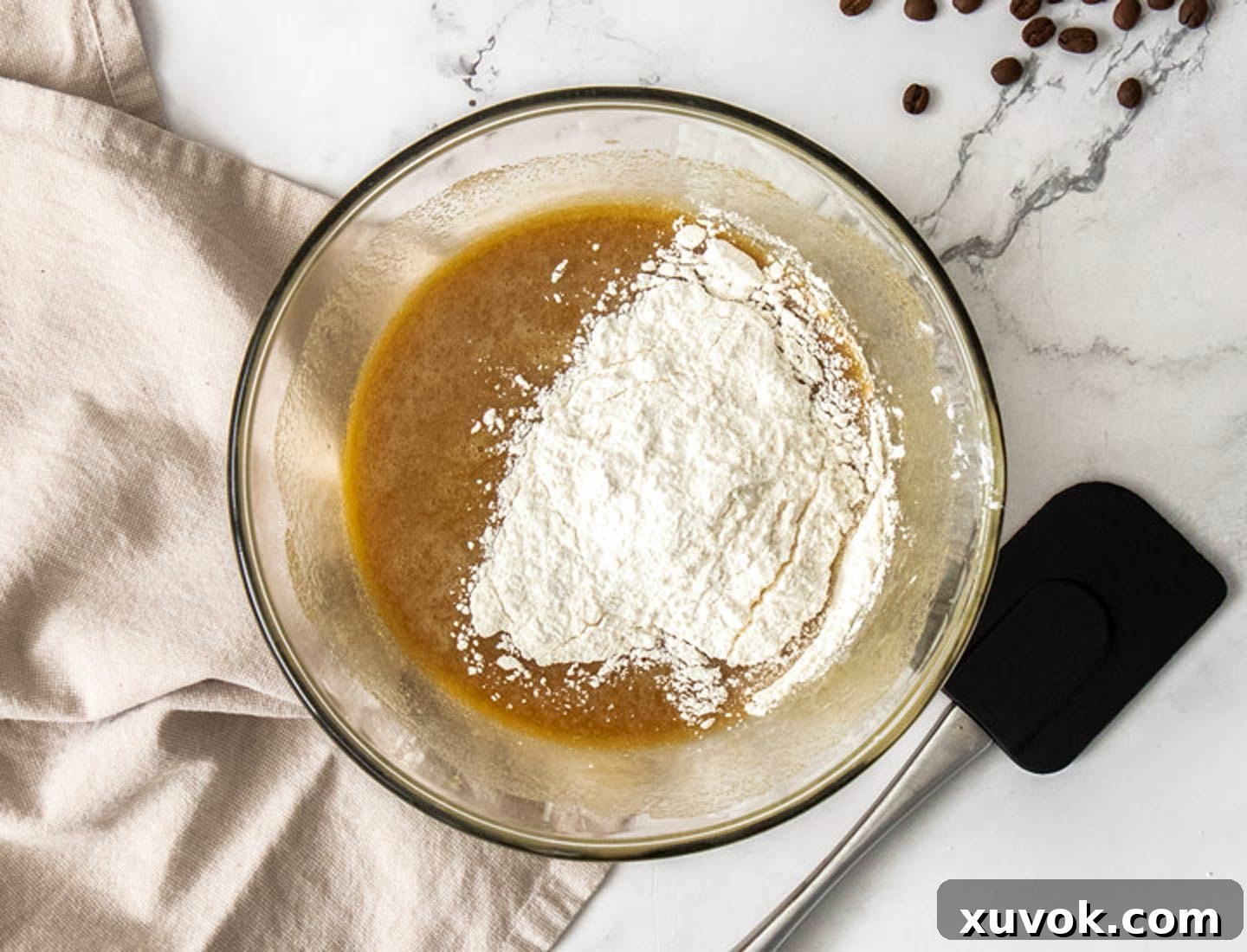 The flour being added to the wet ingredients.
