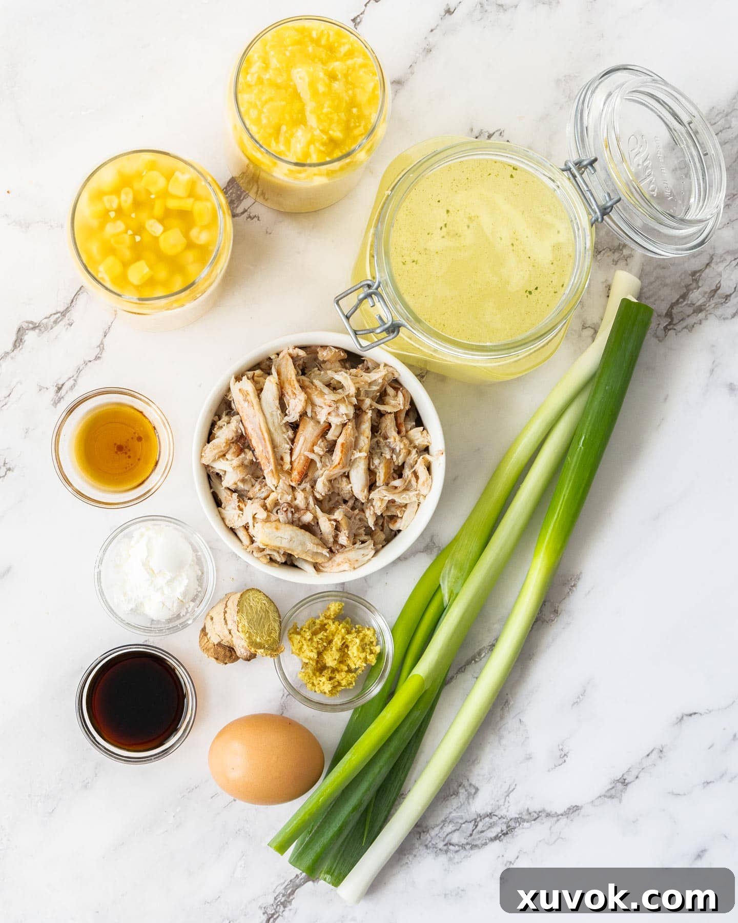 Ingredients for crab and sweetcorn soup on a marble surface.