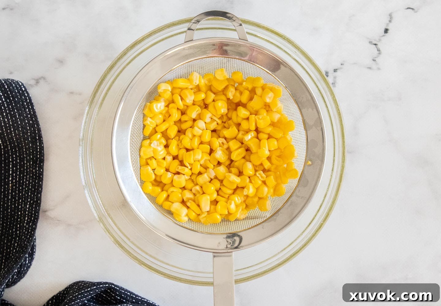 Draining the corn in a sieve.