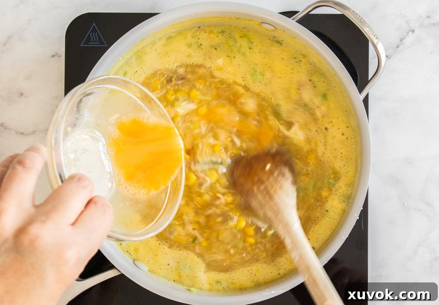 Adding the egg to the saucepan.
