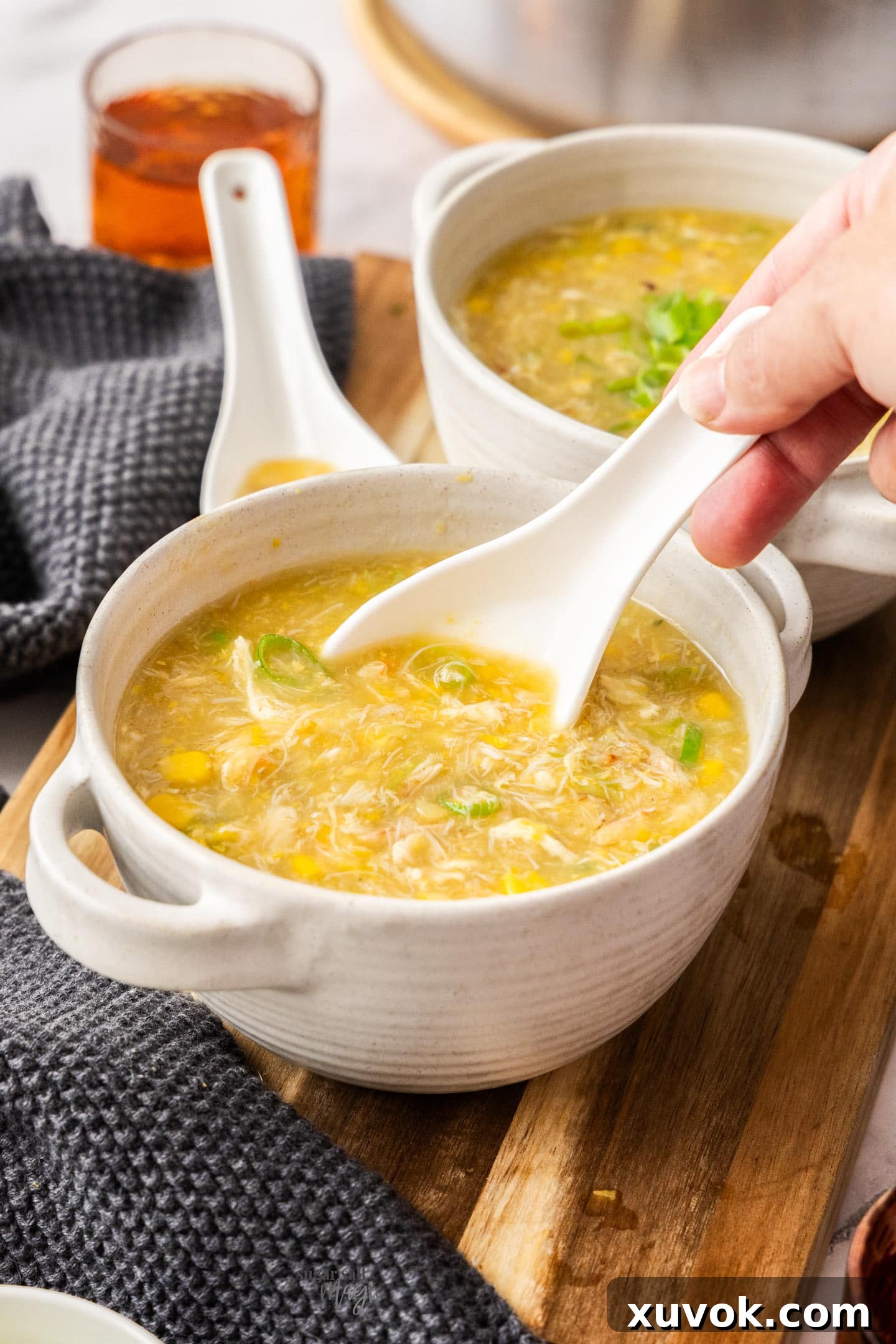 A Chinese soup spoon in a bowl of crab and corn soup.