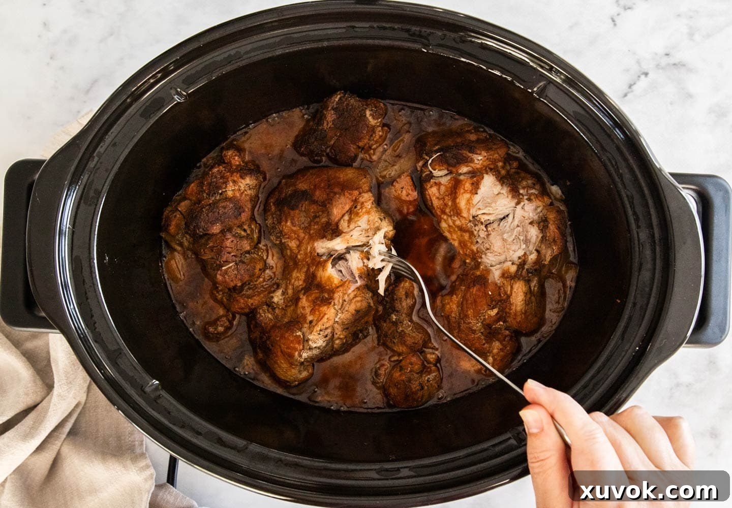 A fork gently pulling apart the pork.