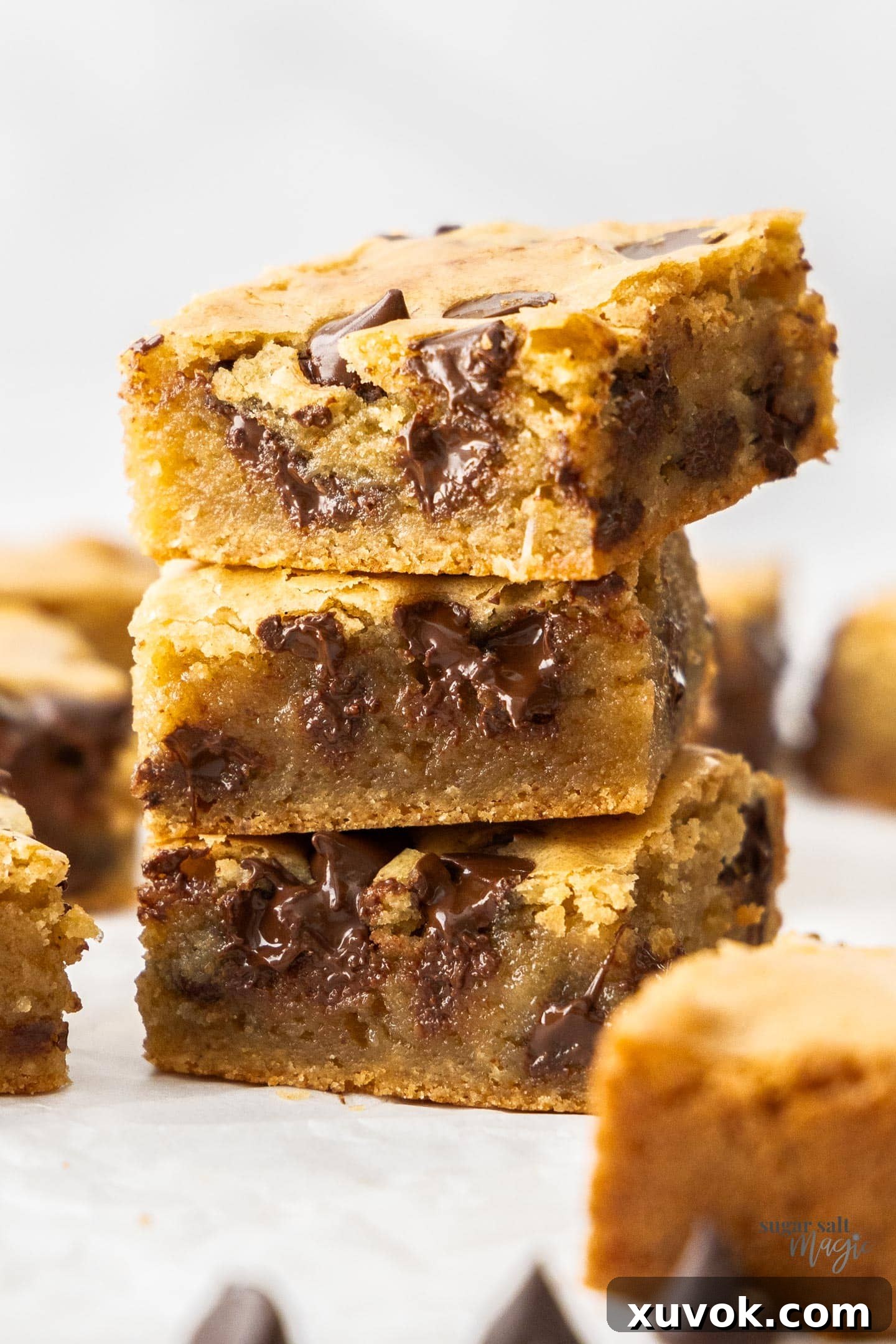 A stack of 3 browned butter blondies, showcasing their fudgy texture and melted chocolate chips.