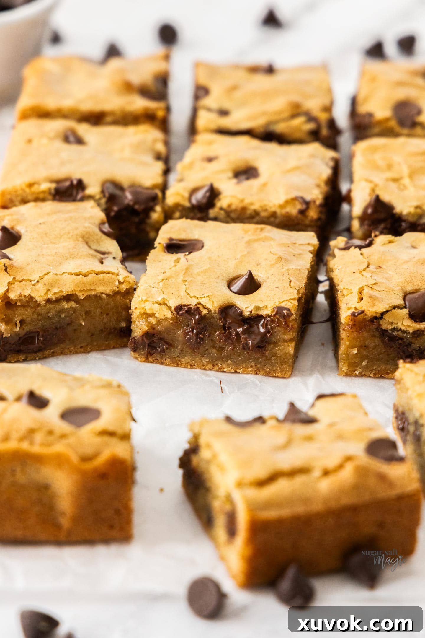 A fresh batch of golden-brown brown butter blondies cooling on a sheet of baking paper.