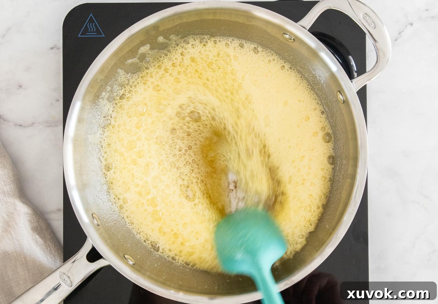 The butter in a saucepan achieving a foamy, golden-brown state, indicating perfect browning.