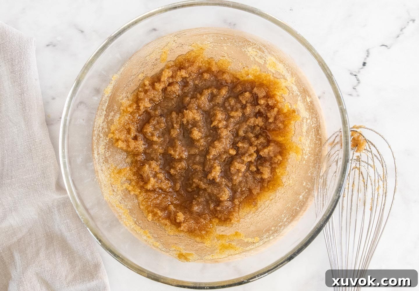 Granulated and brown sugars being mixed into the cooled brown butter in a bowl.