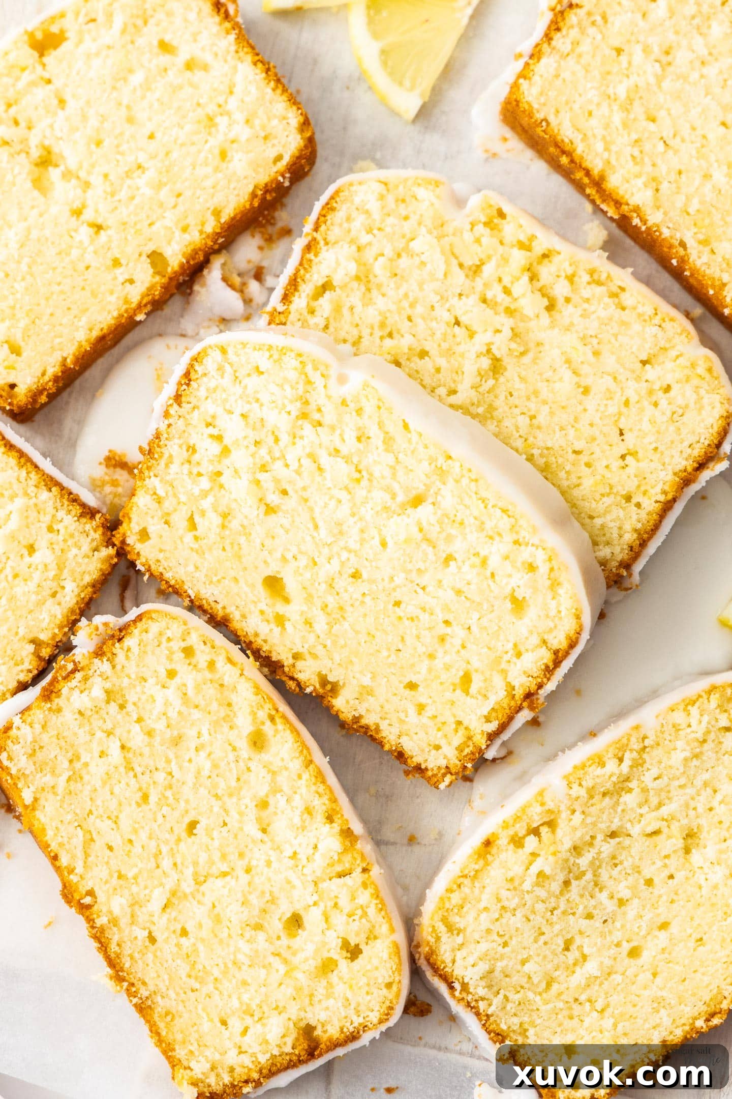 Top down view of 7 slices of lemon loaf cake, showcasing its moist texture and golden crust with a delicate lemon glaze.