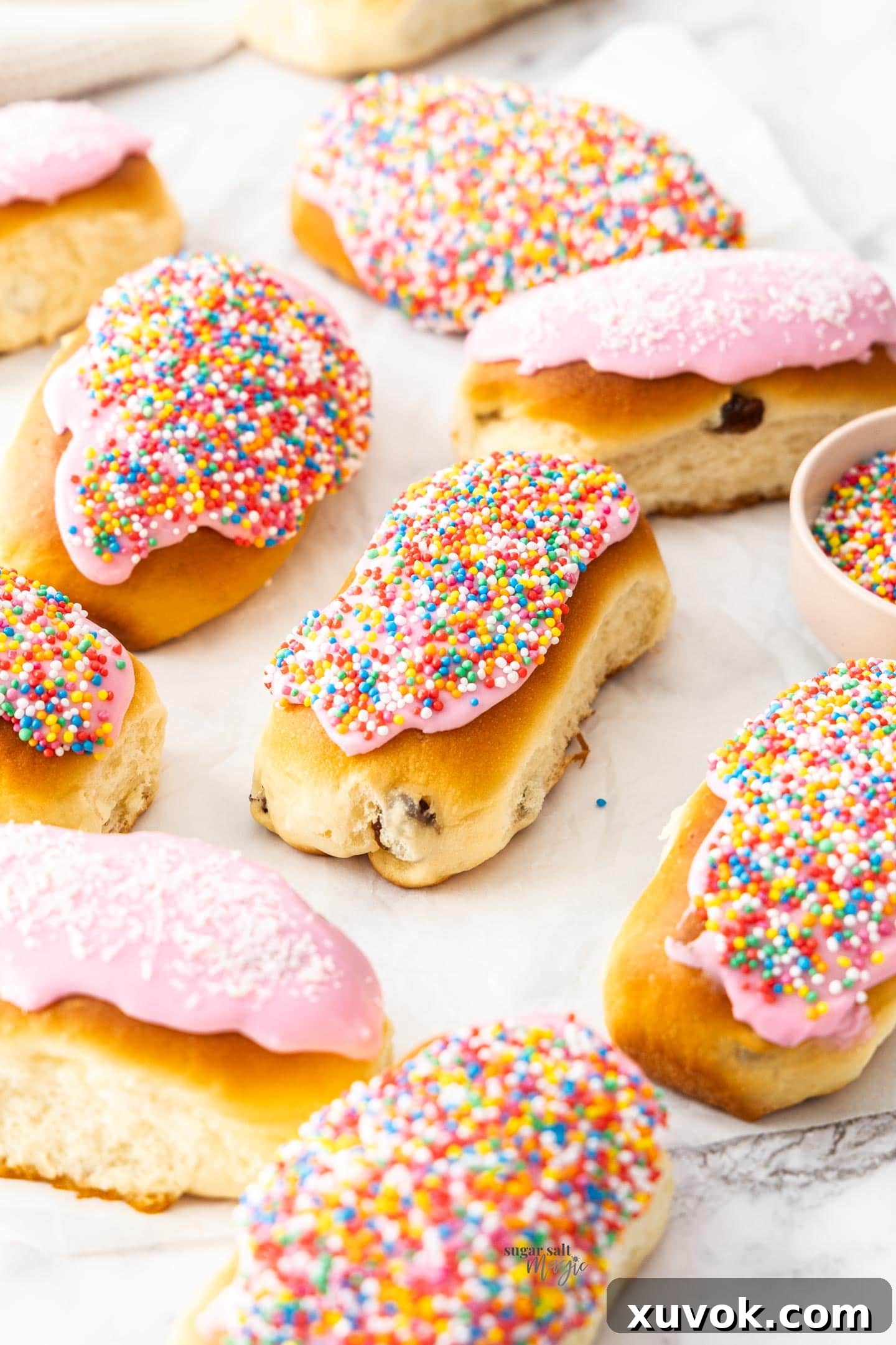 A cluster of freshly baked and iced finger buns, artfully arranged on a marble surface, ready to be enjoyed.