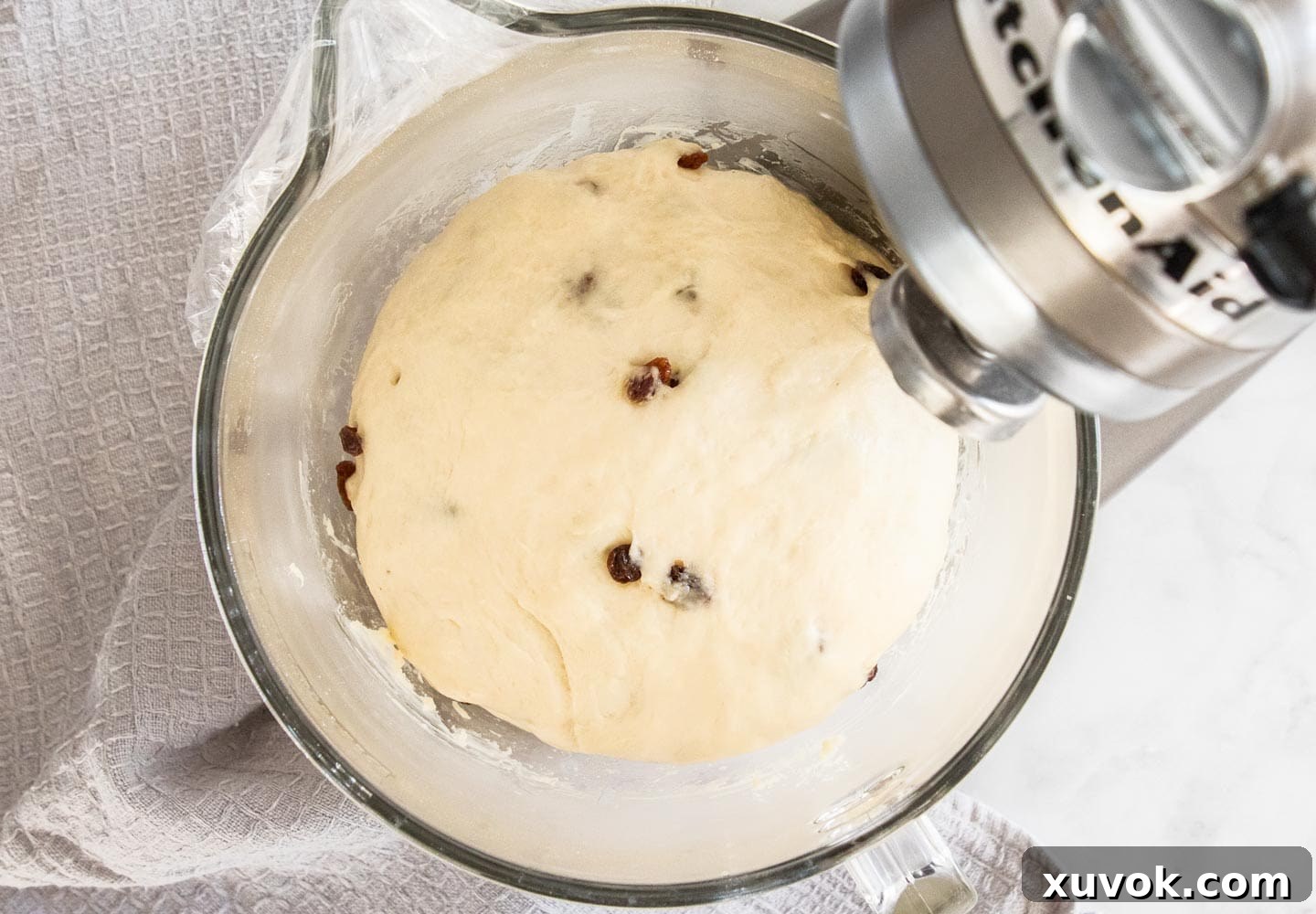 Finger bun dough after its first rise, beautifully puffed up and doubled in size within the mixing bowl.