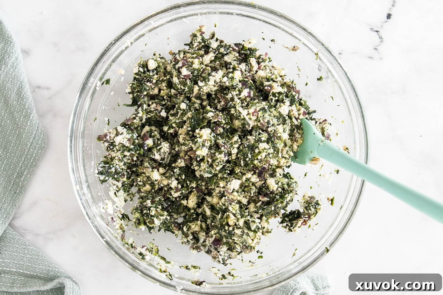 A bowl filled with the creamy, cheesy spinach and feta parcel filling, ready for assembly.