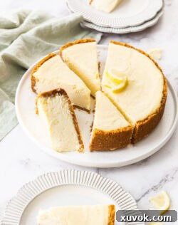 Baked lemon cheesecake cut into slices on a cake plate.