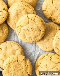 Top down view of a batch of peanut butter cookies on a sheet of baking paper.