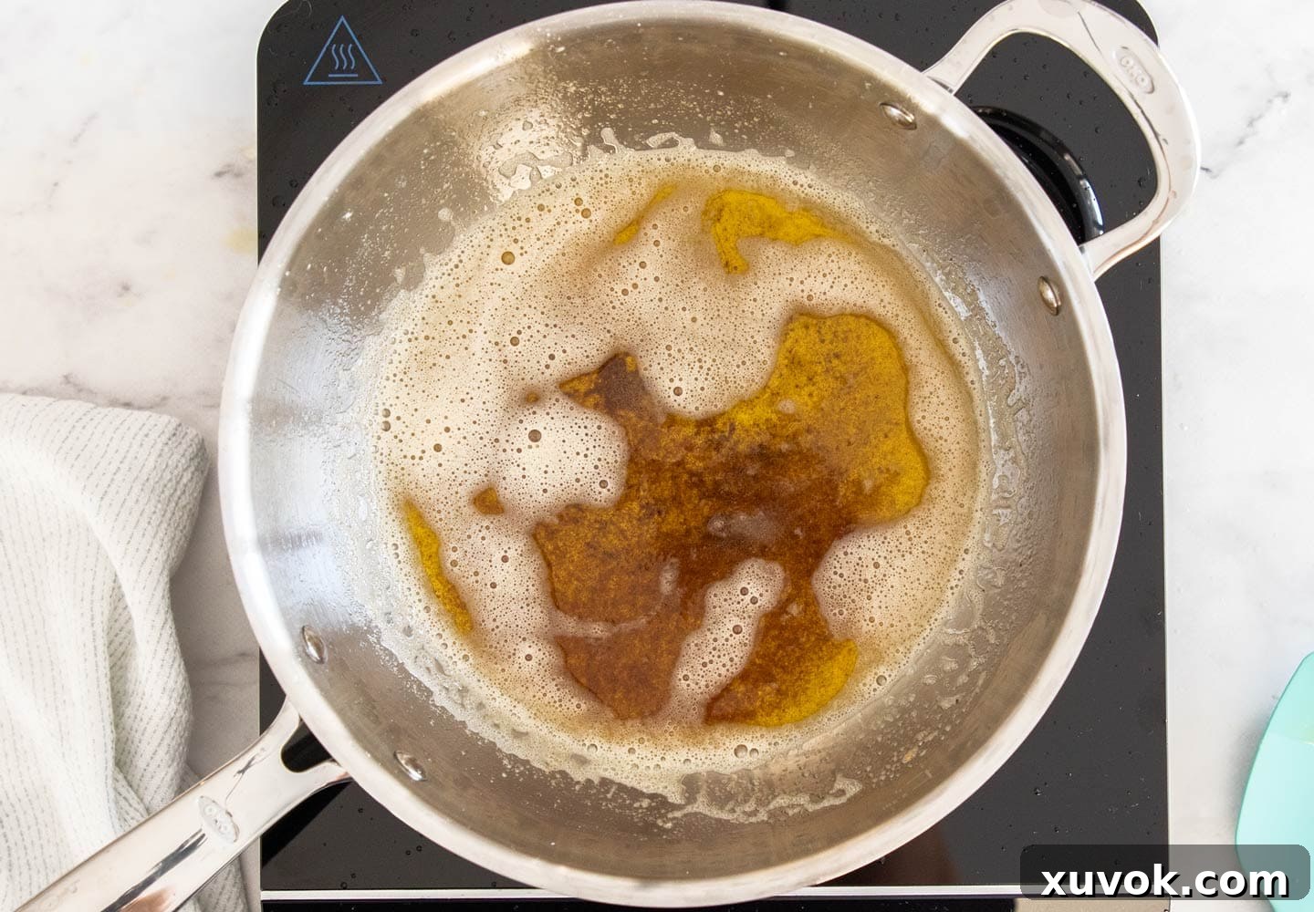 Close-up shot of perfectly browned butter swirling in a pan, showcasing its rich amber color and the toasted milk solids.