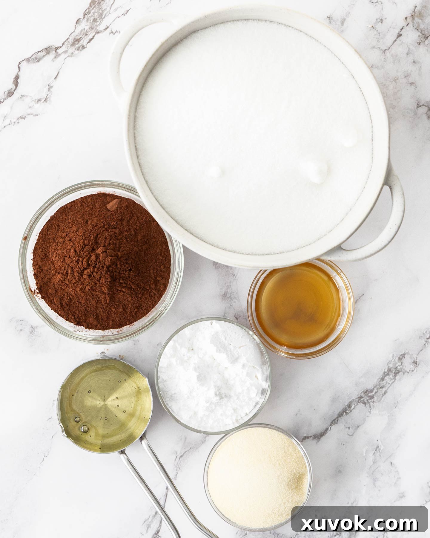 All the shelf-stable ingredients laid out for making chocolate marshmallows, including cocoa powder, sugar, and gelatin.