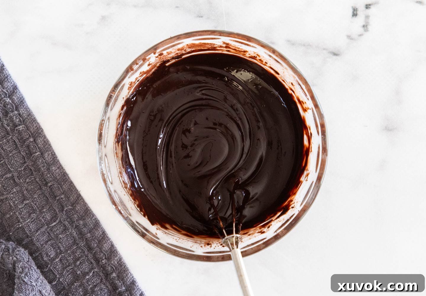 A thick, smooth cocoa paste in a small bowl, prepared by blooming the cocoa powder.