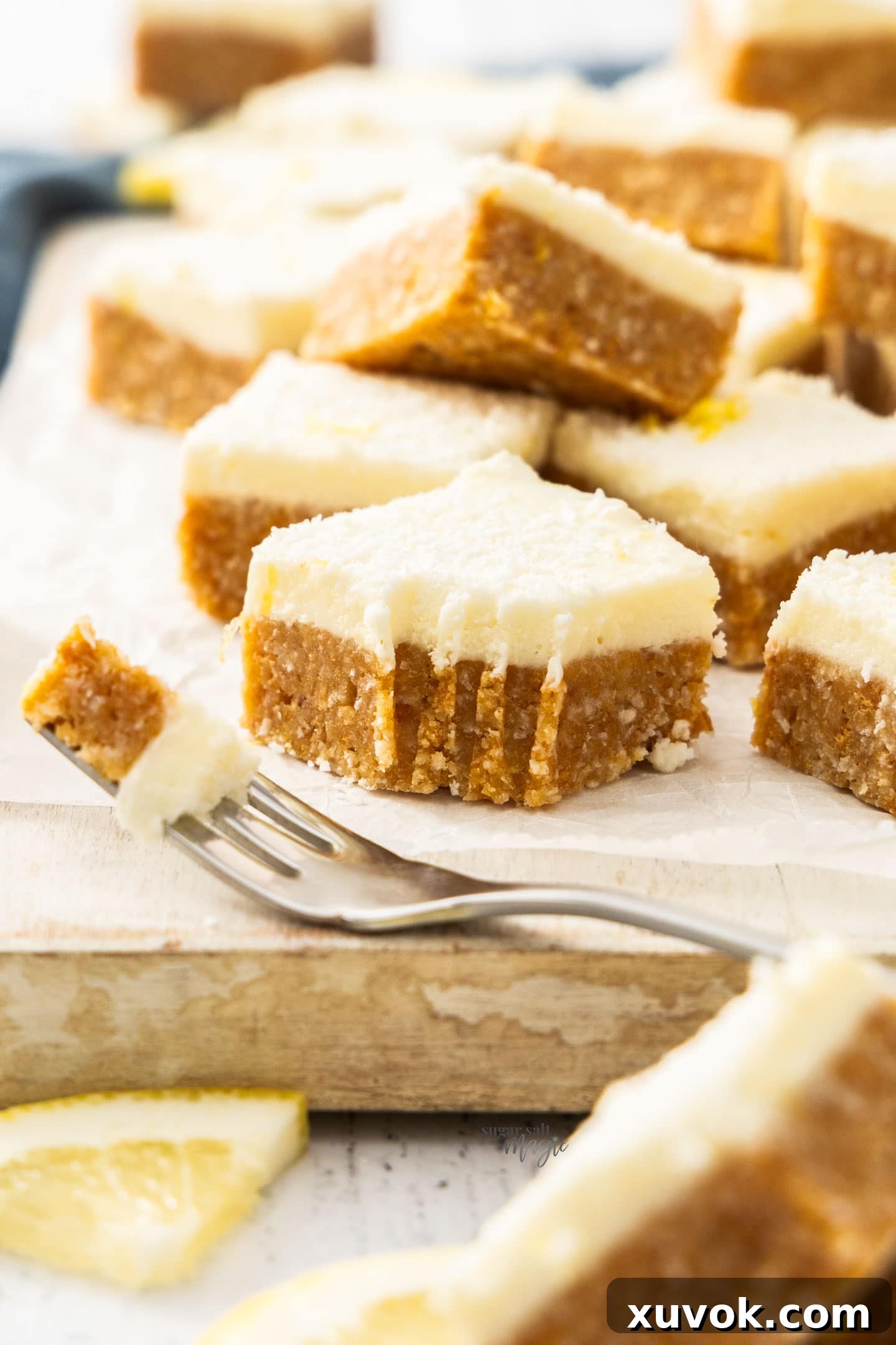 A single square of lemon coconut slice with a forkful carefully cut away, highlighting the soft texture.