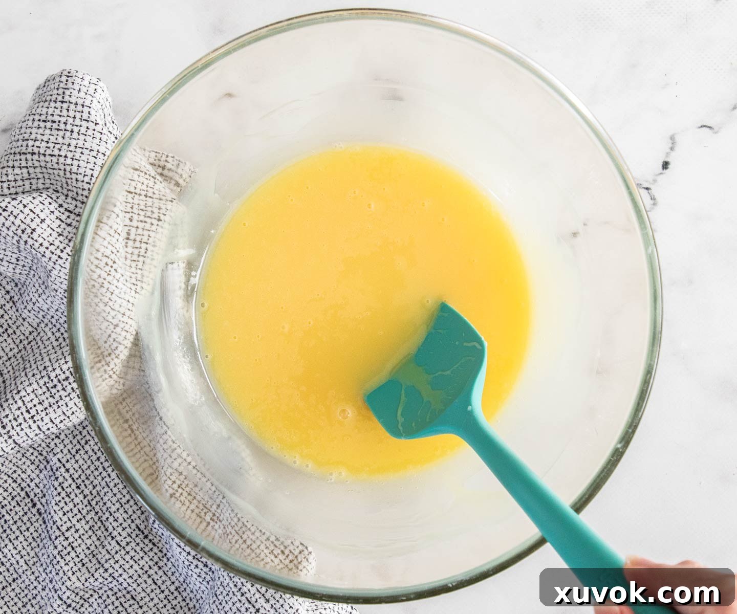 Melted butter and condensed milk perfectly combined in a glass bowl.